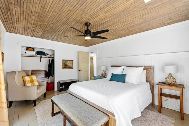 bedroom with crown molding, a ceiling fan, wood finished floors, and a closet