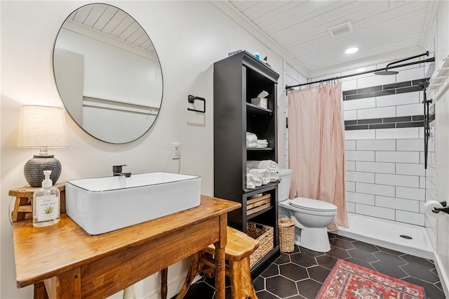 full bathroom with tile patterned flooring, a sink, a tile shower, and toilet