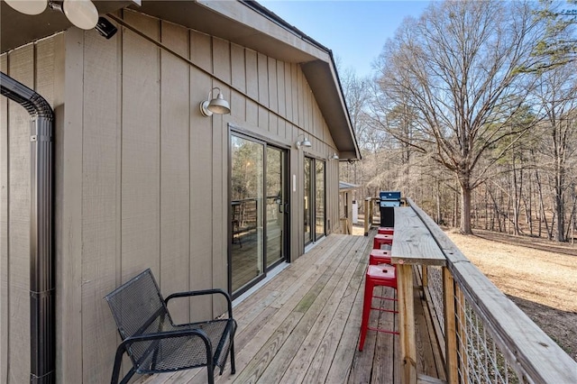 wooden terrace with area for grilling and ceiling fan