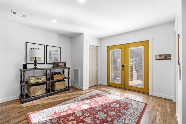 entrance foyer with baseboards, visible vents, french doors, and wood finished floors