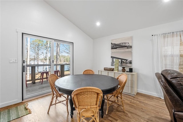 dining room featuring light wood-style floors, baseboards, recessed lighting, and high vaulted ceiling