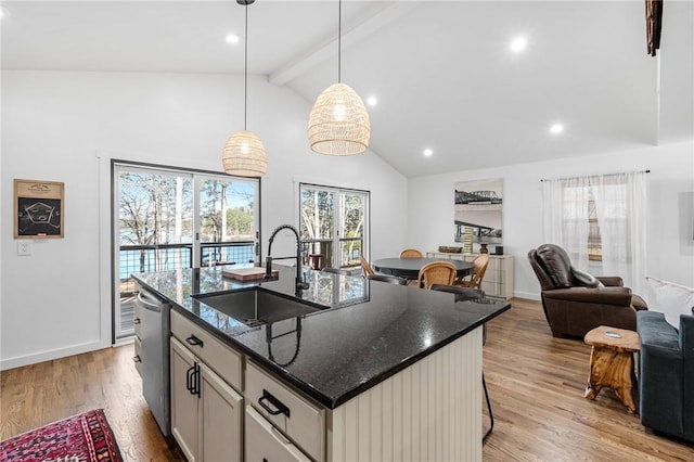 kitchen with dishwasher, a sink, beamed ceiling, a breakfast bar, and light wood-style flooring