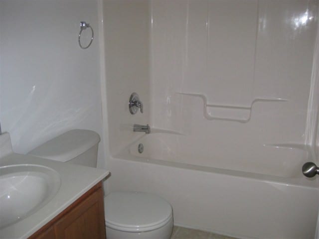 full bathroom with shower / bathtub combination, vanity, and toilet