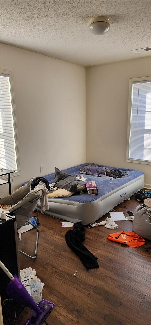 miscellaneous room with wood-type flooring, a wealth of natural light, and a textured ceiling