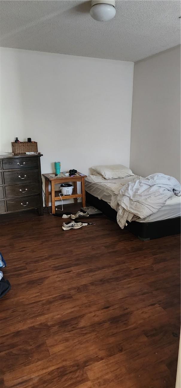 bedroom with dark hardwood / wood-style flooring and a textured ceiling