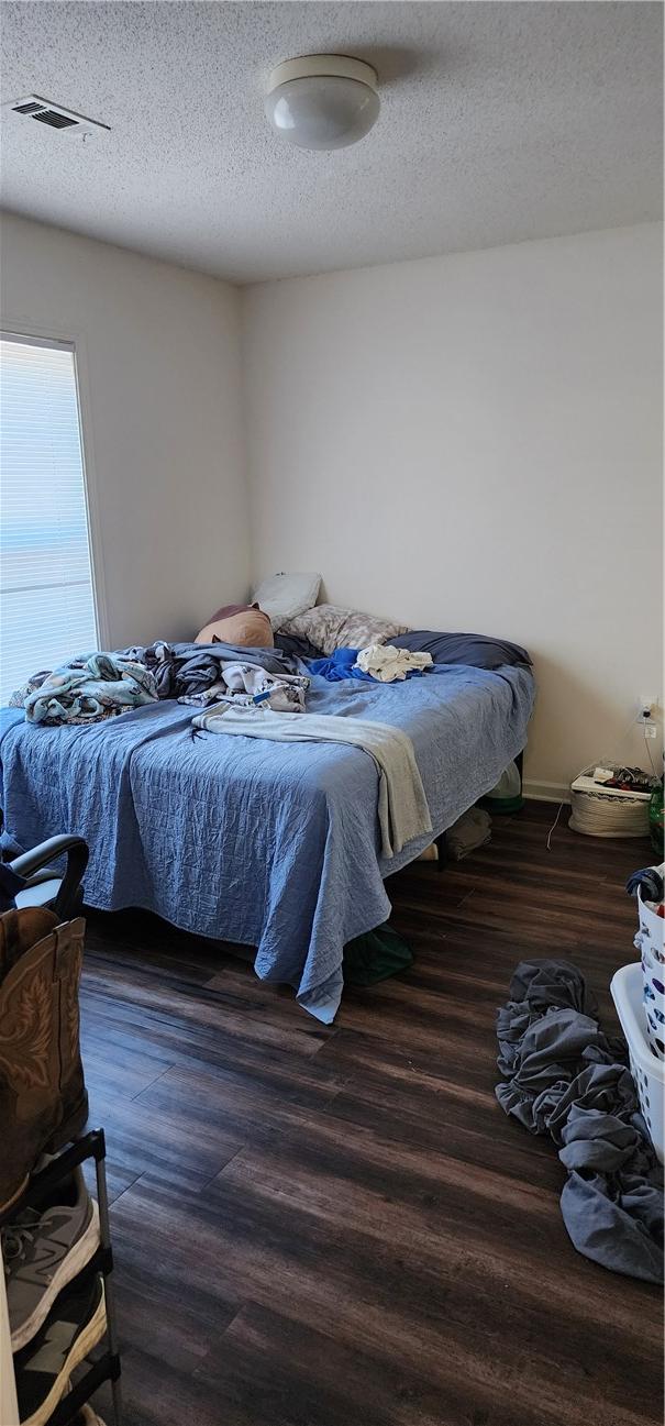 bedroom featuring dark hardwood / wood-style floors and a textured ceiling