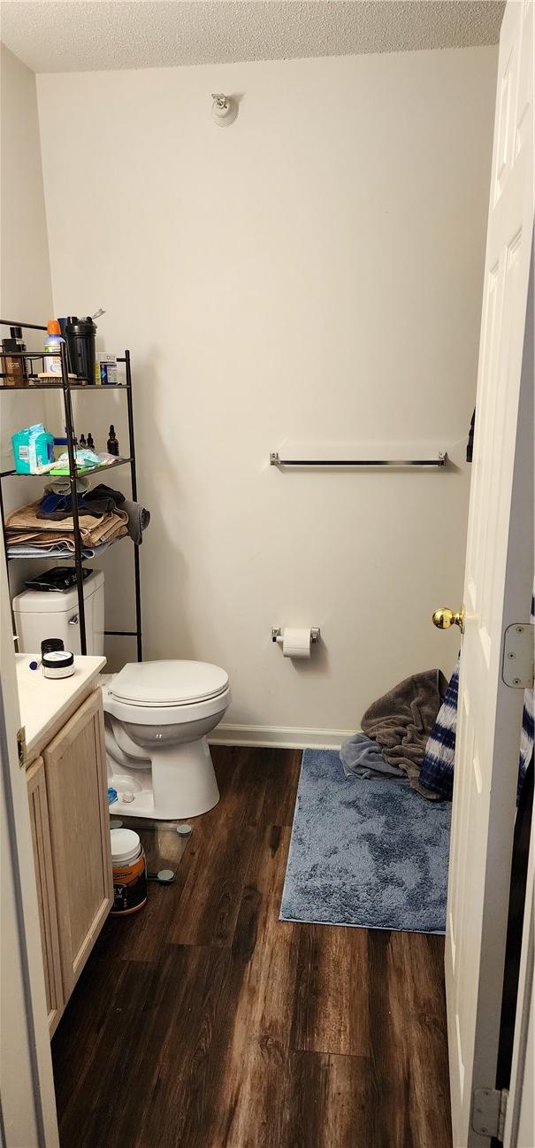 bathroom with vanity, hardwood / wood-style flooring, toilet, and a textured ceiling