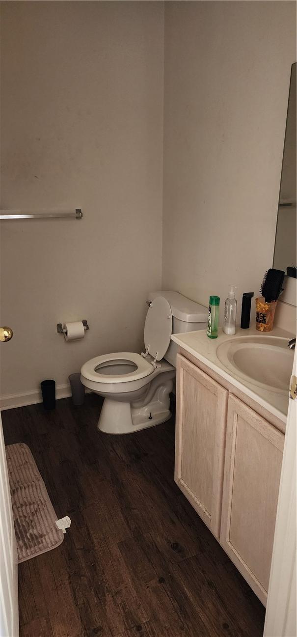 bathroom featuring vanity, wood-type flooring, and toilet