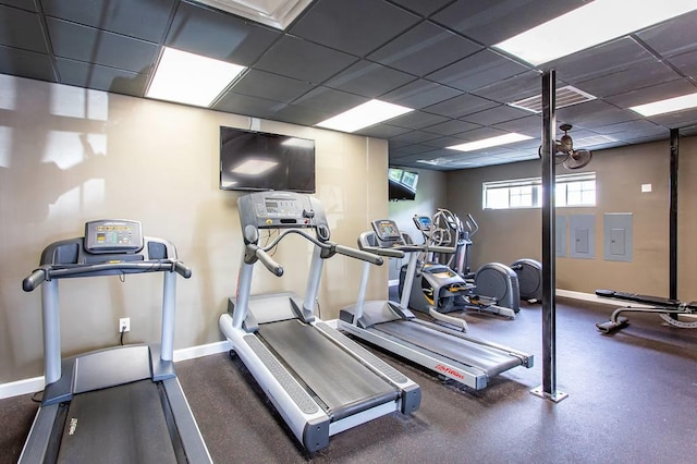 gym with a drop ceiling and electric panel