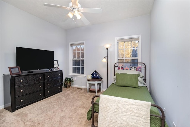 carpeted bedroom featuring multiple windows and ceiling fan