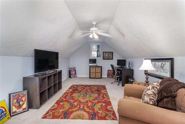 carpeted office space featuring vaulted ceiling, ceiling fan, and a textured ceiling