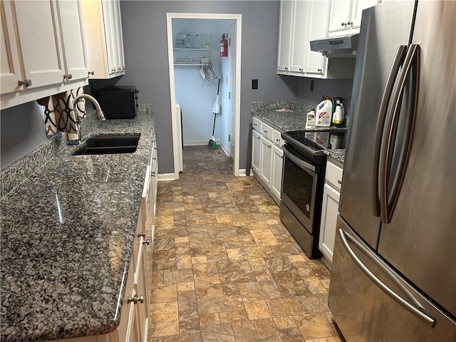 kitchen featuring white cabinetry, sink, stainless steel appliances, and dark stone counters