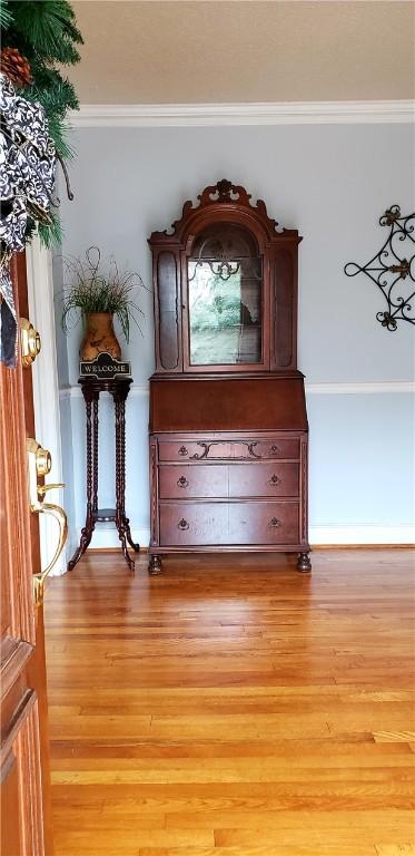 details with wood-type flooring and crown molding