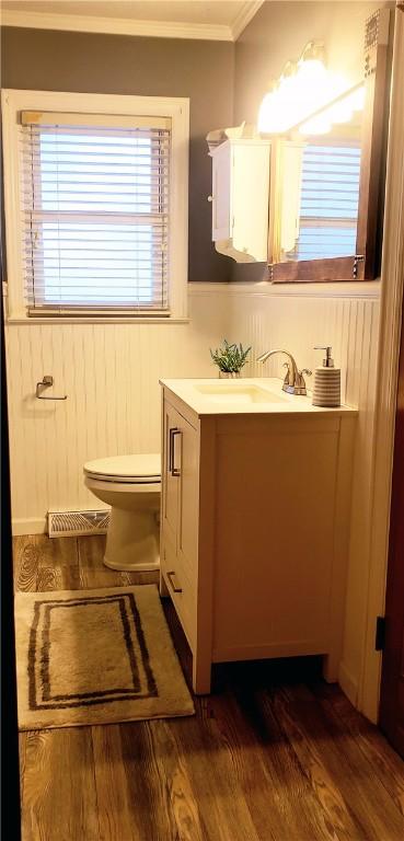 bathroom featuring ornamental molding, toilet, hardwood / wood-style floors, and vanity