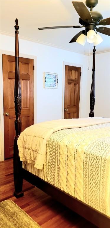 bedroom featuring hardwood / wood-style flooring, ceiling fan, and ornamental molding