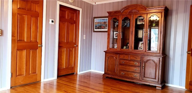 interior space with ornamental molding and hardwood / wood-style floors