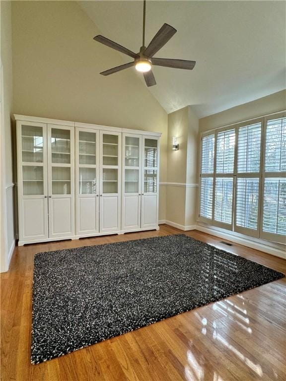 unfurnished living room with ceiling fan, high vaulted ceiling, and hardwood / wood-style floors