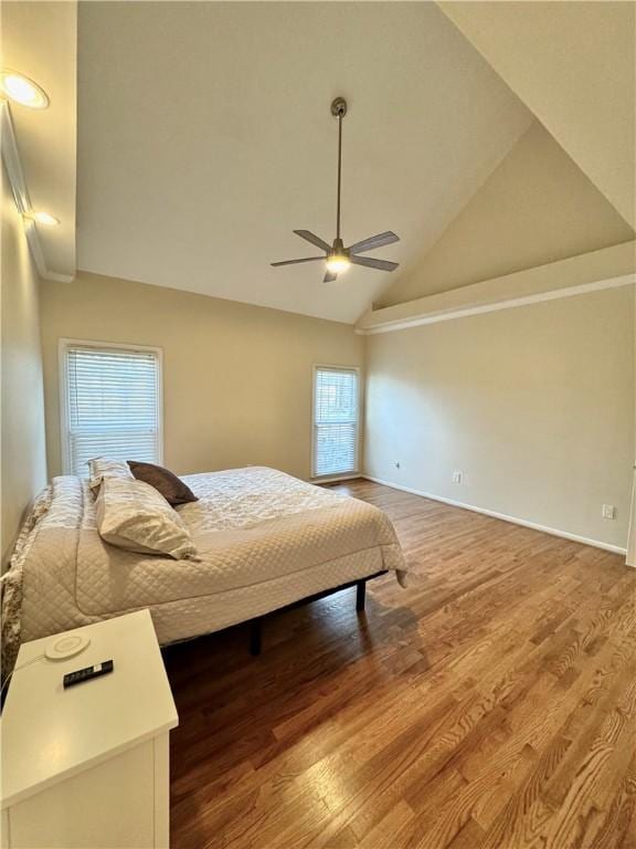 bedroom featuring multiple windows, lofted ceiling, hardwood / wood-style floors, and ceiling fan