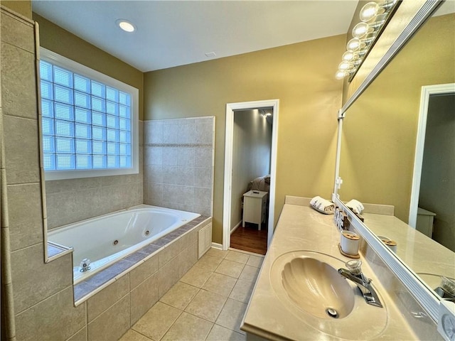 bathroom featuring tile patterned flooring, vanity, and a relaxing tiled tub