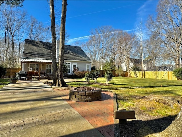 exterior space featuring an outdoor fire pit, a patio, and a lawn