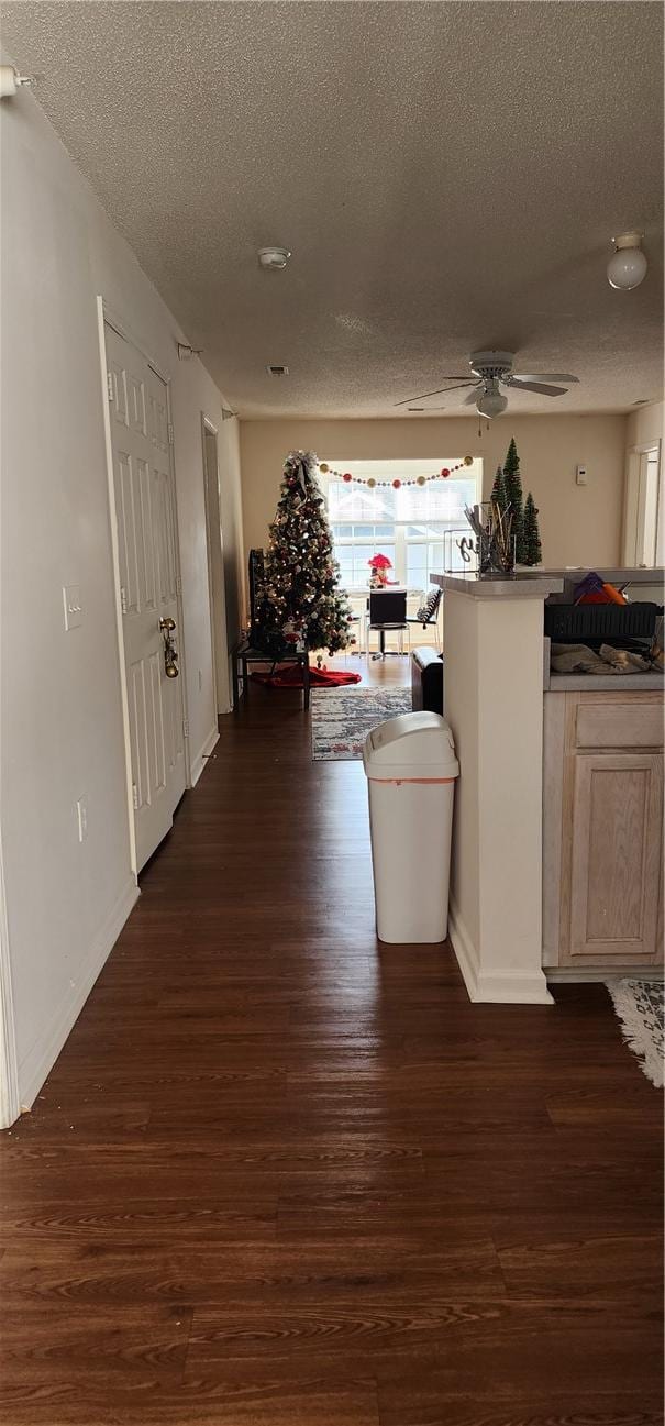 hall with dark hardwood / wood-style floors and a textured ceiling