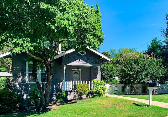 bungalow-style home featuring a front lawn and covered porch