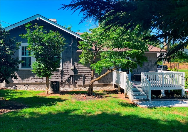 view of property exterior with a wooden deck, central AC unit, and a lawn