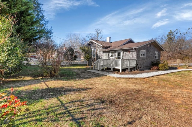 view of property exterior with a deck and a lawn