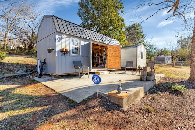 rear view of house featuring a patio and a shed