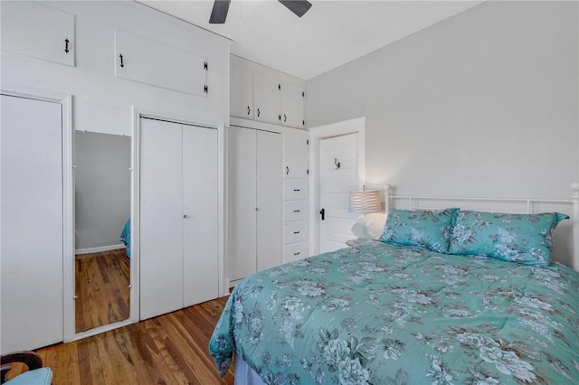 bedroom featuring dark hardwood / wood-style flooring, multiple closets, and ceiling fan