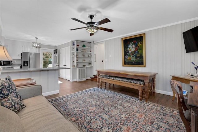 living room with crown molding, ceiling fan with notable chandelier, and dark hardwood / wood-style flooring