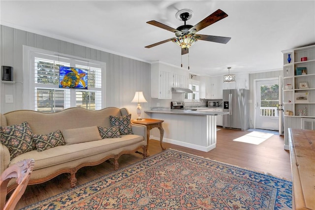 living room with ceiling fan, ornamental molding, and hardwood / wood-style floors