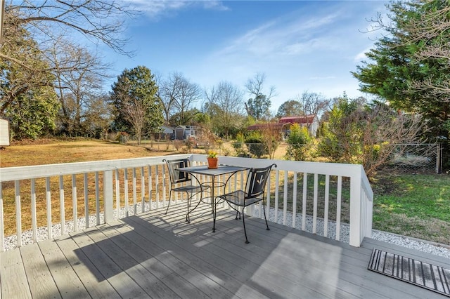 wooden terrace featuring a yard