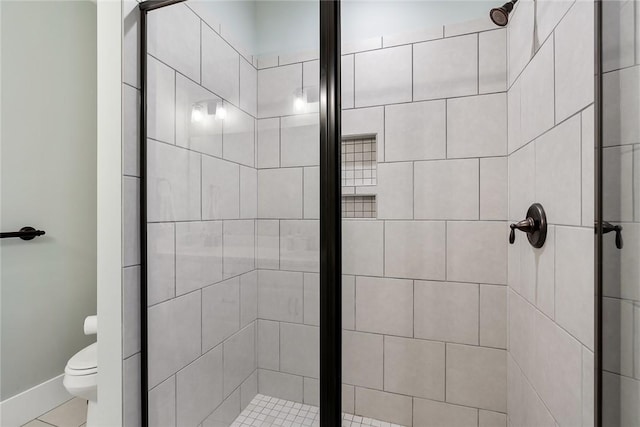 bathroom featuring toilet, tile patterned flooring, and a shower with door