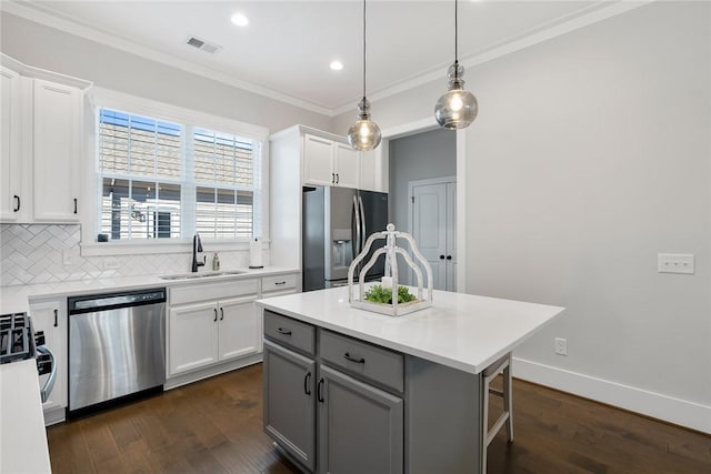 kitchen with sink, stainless steel appliances, a center island, tasteful backsplash, and white cabinets