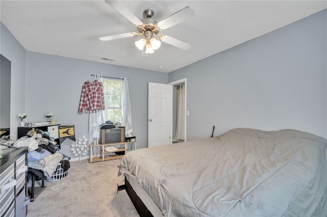 bedroom featuring light colored carpet and ceiling fan