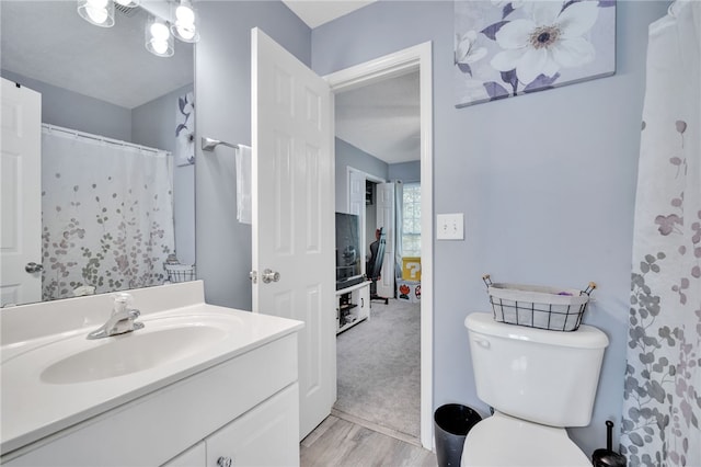 bathroom featuring vanity, wood-type flooring, toilet, and a shower with shower curtain