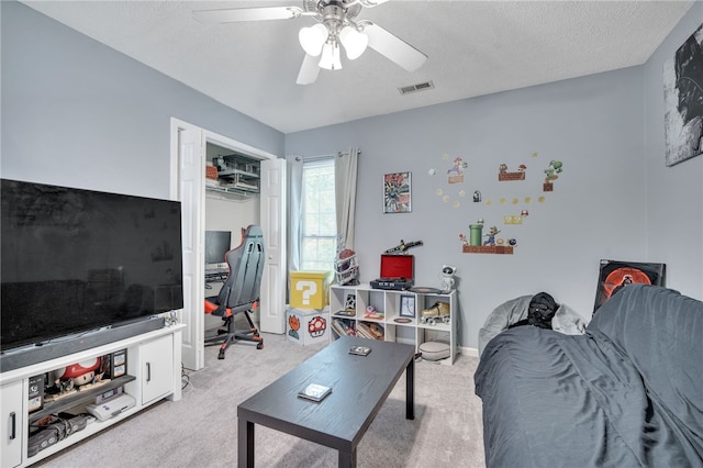 carpeted living room with ceiling fan and a textured ceiling