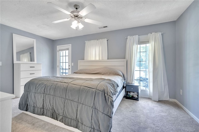 carpeted bedroom with a textured ceiling and ceiling fan