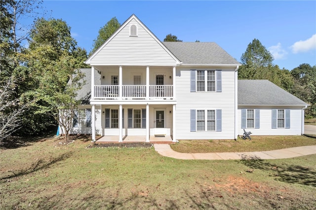 view of front of house with a porch, a balcony, and a front lawn