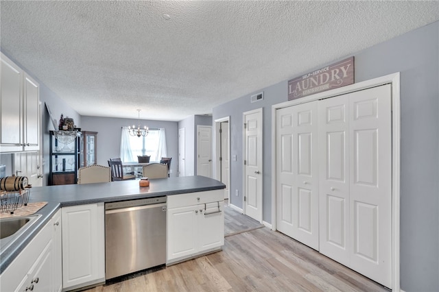 kitchen featuring stainless steel dishwasher, a textured ceiling, hanging light fixtures, and white cabinets