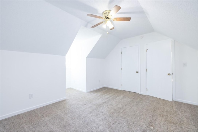 additional living space with lofted ceiling, light carpet, and ceiling fan