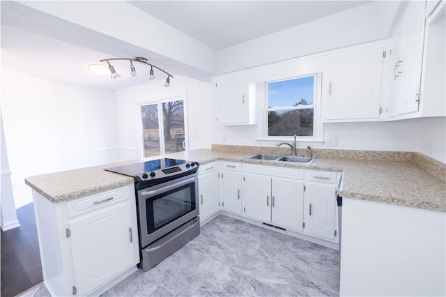 kitchen featuring white cabinetry, stainless steel electric range oven, sink, and kitchen peninsula