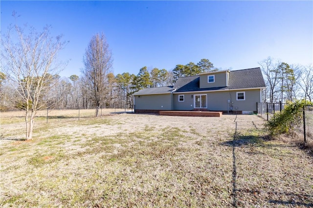 rear view of property featuring a lawn