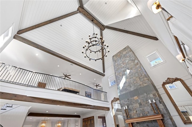 interior details featuring beamed ceiling and ceiling fan with notable chandelier