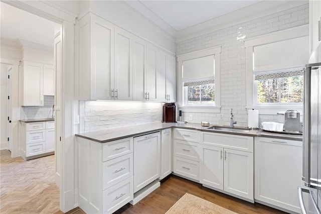 kitchen with stainless steel refrigerator, white cabinetry, sink, decorative backsplash, and white dishwasher