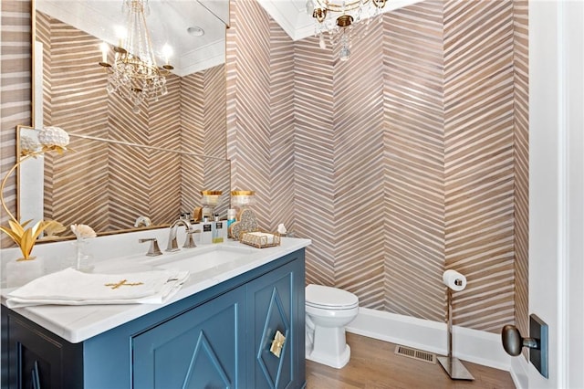 bathroom with vanity, a notable chandelier, wood-type flooring, and toilet