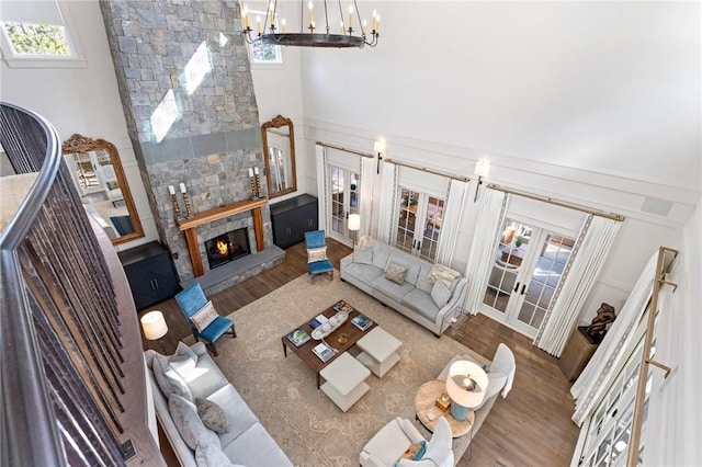 living room with wood-type flooring, plenty of natural light, a fireplace, and french doors