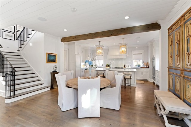 dining area with beamed ceiling and dark hardwood / wood-style flooring