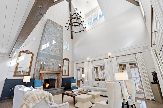 living room featuring plenty of natural light, beam ceiling, high vaulted ceiling, and a stone fireplace